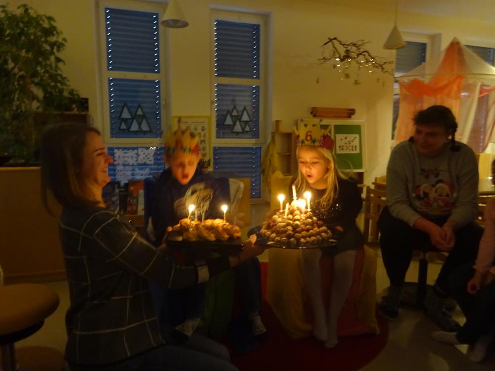Kinder blasen Kerzen am Kuchen aus